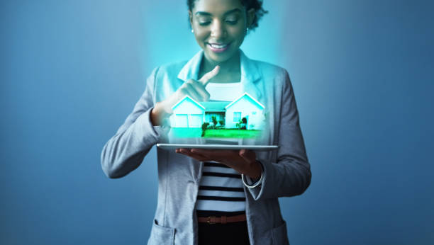Your perfect home is just an app away Studio shot of a young businesswoman using a digital tablet with property graphics against a blue background mobile real estate stock pictures, royalty-free photos & images