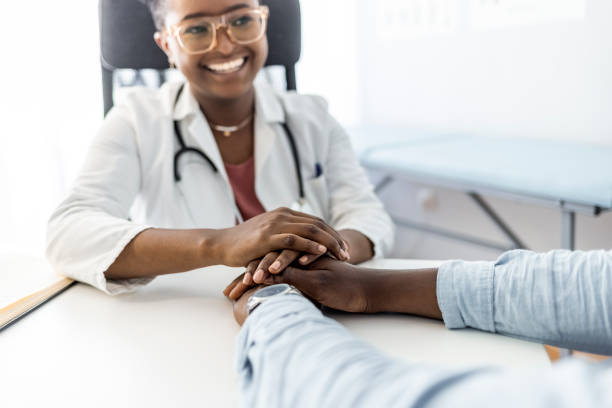 You're in a safe space now Female doctor holding patient's hands while sitting in doctor office during the day. patience stock pictures, royalty-free photos & images