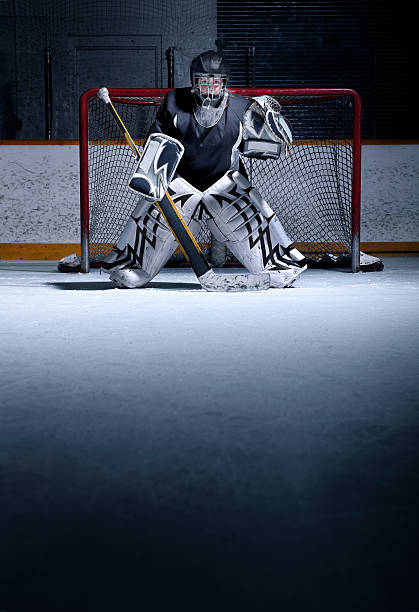 Youth Hockey Goalie A young, female, hockey goalie in position on the ice. There is ample copy space. goalie stock pictures, royalty-free photos & images