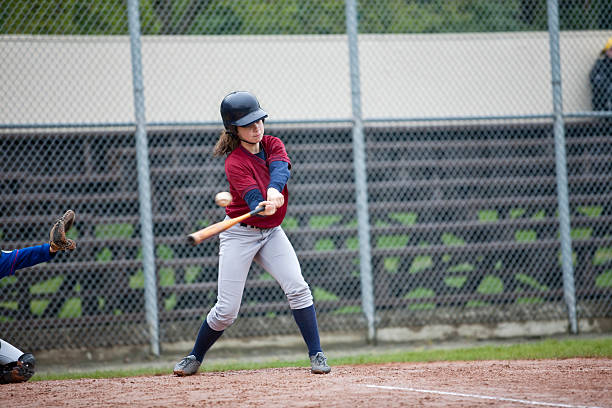 Youth League Batter Hitting Baseball Girl Hitting the Baseball (she made it to second base) batting sports activity stock pictures, royalty-free photos & images