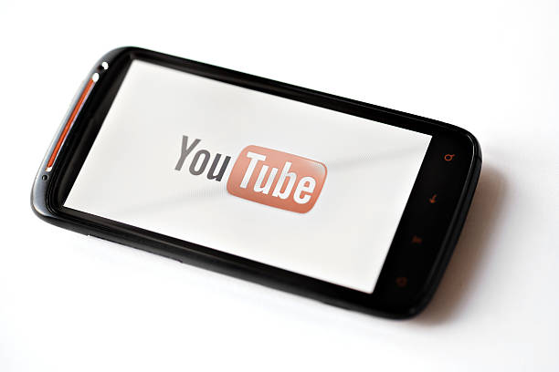 Youtube phone Bucharest, Romania - March 28, 2012: Youtube logo is displayed on a mobile phone screen. YouTube is a video-sharing website, on which users can upload, view and share videos. youtube stock pictures, royalty-free photos & images