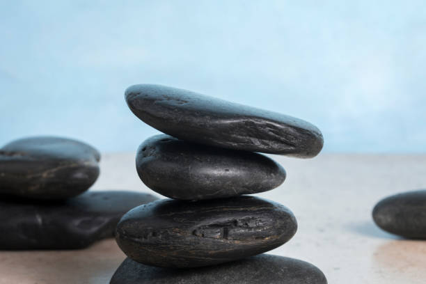 Zen black stone cairn with blue background stock photo