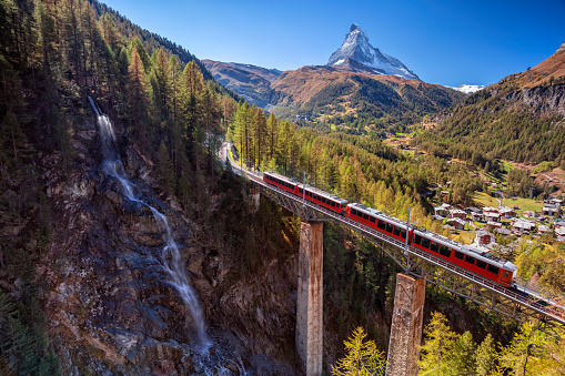 Image of Swiss Alps with Gornergrad tourist train, waterfall and Matterhorn in Valais region.