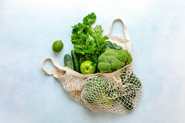 Zero waste consumption concept View from above on eco friendly bag filled with green organic vegetables, zero waste informed consumption concept zero waste photos stock pictures, royalty-free photos & images