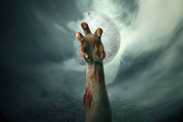 Zombie hand with blood and wound raised stock photo