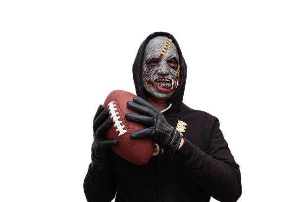 A zombie holding an American football ball stock photo