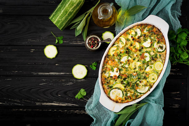 Zucchini casserole with eggs, milk, cheese and greens herbs. Flat lay. Top view Zucchini casserole with eggs, milk, cheese and greens herbs. Flat lay. Top view gratin stock pictures, royalty-free photos & images