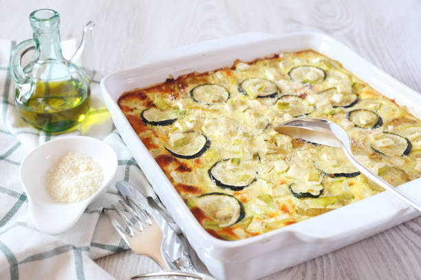 Zucchini gratin Zucchini gratin with parmesan cheese and olive oil on light background gratin stock pictures, royalty-free photos & images