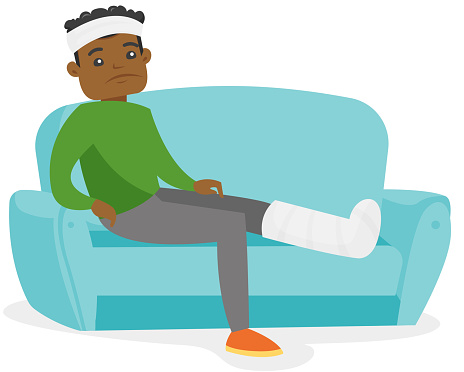 African man with broken leg sitting on the couch