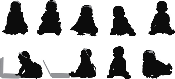 Baby silhouettes sitting up using laptop computer