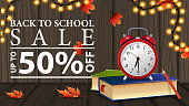 istock Back to school sale, discount web banner with wooden texture, school books and alarm clock 1337833903