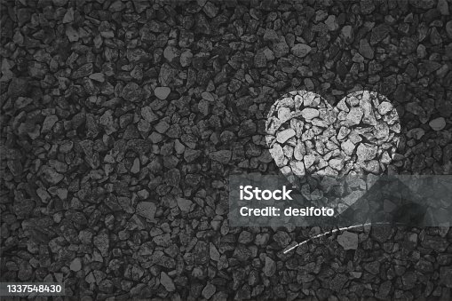 istock Black and white coloured pebbles making a heart painted on gravel road; Valentine's Day or anniversary love greetings related vector backgrounds 1337548430