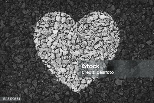 istock Black and white coloured pebbles making one big heart painted on gravel road; Valentine's Day or anniversary love greetings related vector backgrounds 1343190381