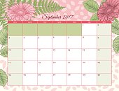 2017 Botanical Floral Desk Pad calendar Template. Assorted leaves and flowers drawn in detailed botanical style frame the pastel calendar sections.The background has a soft pastel pattern. Shades of pinks and greens.