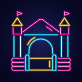 istock Bouncy castle neon icon. Jumping house on kids playground. Vector illustration. 1354722666