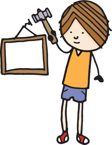Boy hanging picture frame with a hammer