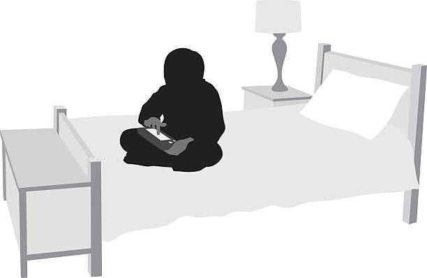 Boys Gaming Practice A vector silhouette illustration of a young boy sitting on his bed alone in his bedroom playing a handheld game. bedroom silhouettes stock illustrations