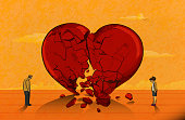 Unhappy sad couple standing in front of the huge broken heart having relationship problems. (Used clipping mask)