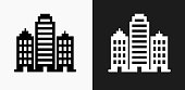 Buildings Icon on Black and White Vector Backgrounds. This vector illustration includes two variations of the icon one in black on a light background on the left and another version in white on a dark background positioned on the right. The vector icon is simple yet elegant and can be used in a variety of ways including website or mobile application icon. This royalty free image is 100% vector based and all design elements can be scaled to any size.