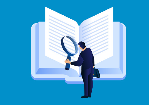 Businessman holding a magnifying glass flipping through books