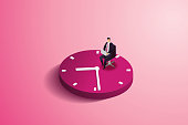 istock Businessman sitting in a chair on a large clock. 1366046926