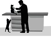 A vector silhouette illustration of a veteranarian using his stethoscope to listen to a kitten.  A second cat plays on the floor.