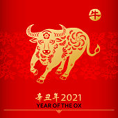 Celebrate the Year of the Ox 2021 with the gold colored paper cut on floral background, the Chinese stamp means Ox and the Chinese phrase means Year of the Ox according to Chinese calendar