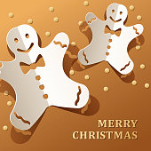 Celebrate Christmas with paper craft of gold colored stars and folded gingerbread men on the metallic gold colored background