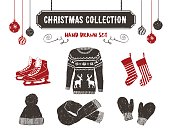 Hand drawn textured vintage Christmas icons set with sweater, ice skates, Christmas stockings, scarf, knitted cap, and mittens vector illustrations.