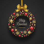 Feliz navidad - Christmas greetings in Spanish. Frame in the form of Christmas wreath - made from stars, ruby gems golden snowflakes, beads and glitter gold bow ribbon.