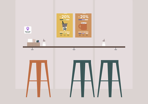 A coffeeshop interior, a bar counter with high stools and promo posters