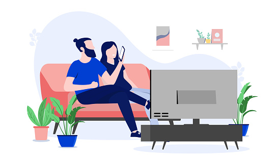 Couple watching TV at home in sofa