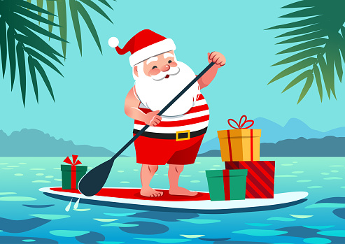 Cute Santa Claus in shorts and t-shirt on a stand up paddle board with gifts, against tropical ocean background with palm trees. Warm weather Christmas celebration, warm climate holiday vacation theme