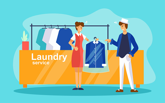 Dry cleaning service concept. Young woman laundry worker stands near reception counter and giving to client bag with clean clothes.