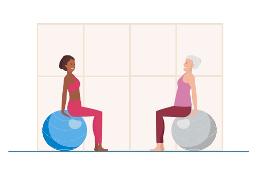 Elderly woman takes lessons of Exercises with fitball. Young African American giving sports lesson. Females doing pilates stretching training, follow healthy lifestyle. Exercises for elderly