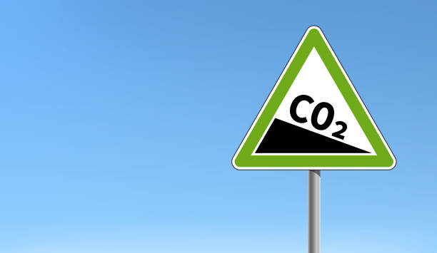 co2-emissionsreduktion zeichen grün dreieckige form blauer himmel - co2 stock-grafiken, -clipart, -cartoons und -symbole