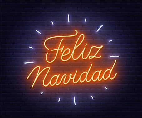 Feliz Navidad neon text. Greeting card on brick wall background .