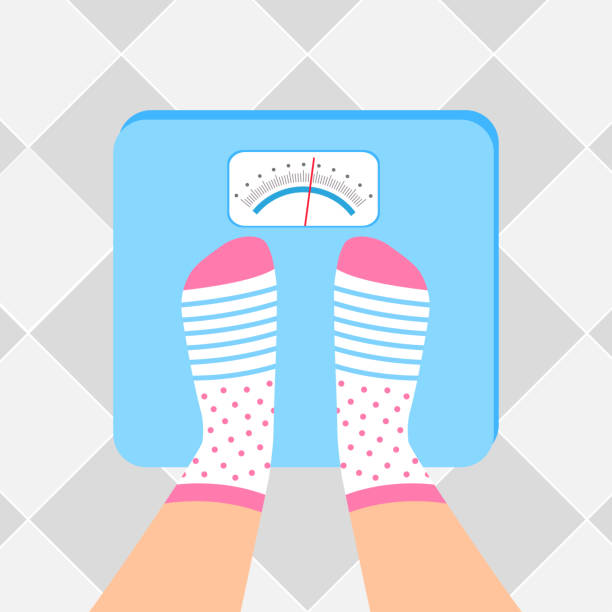 Female feet in socks are on an weighing-machine. The young woman is weighed on scales. Female feet in socks are on an weighing-machine. feet unit of measurement stock illustrations