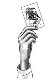 Female hand holding Joker playing card. Casino game retro concept design. Vintage engraving stylized drawing. Vector illustration