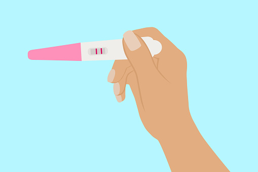 Female Hand Holding Positive Pregnancy Test