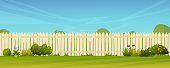 istock Fence and green lawn, rural landscape background. Vector garden backyard with wooden hedge, trees and bushes, grass and flowers, park plants. Spring summer outside landscape. Farm natural agriculture 1309764268