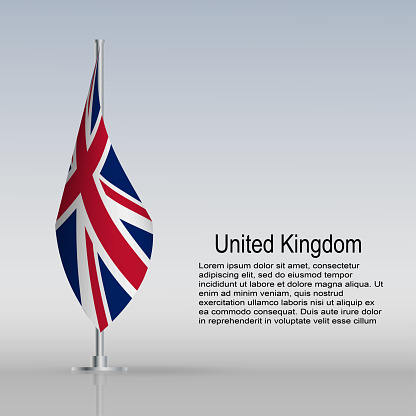 Flag of United Kingdom hanging on a flagpole stands on the table