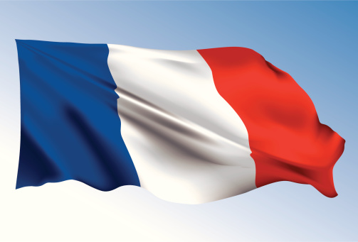French flag waving in wind on blue sky