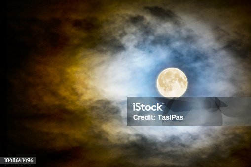 istock Full moon over dark cloudy sky 1048641496