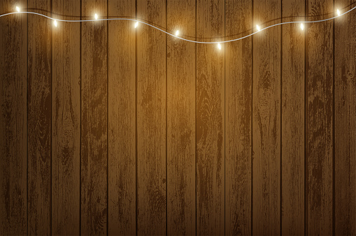 Garland with light bulbs hanging on a wooden wall