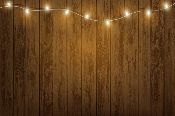 garland mit glühbirnen, die an einer holzwand hängen - holz stock-grafiken, -clipart, -cartoons und -symbole