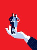 Mentoring!. A stylized vector cartoon reminiscent of an old screen print poster of a giant businessman’s hand holding a tiny standing businessman and woman. Concept to show relationship issues, recruitment, in hand, control, mentoring or management.