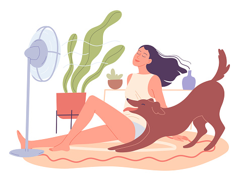Girl and her dog are chilling at home by the fan