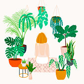 Crazy plant lady. Watering a home garden. Girl meditates on a rug in the interior with potted plants and flowers. Girl resting at home