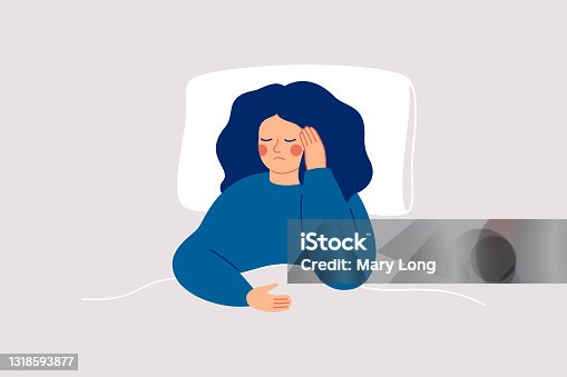 istock Girl suffers from insomnia and had difficulty falling asleep.Woman has headaches during sleep time. Sleepy female lying on bed and touching her temple. Insomnia and sleep disorder. 1318593877